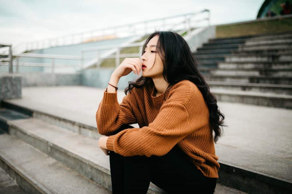 Photo by Anthony Tran woman wearing brown sweater holding lips
