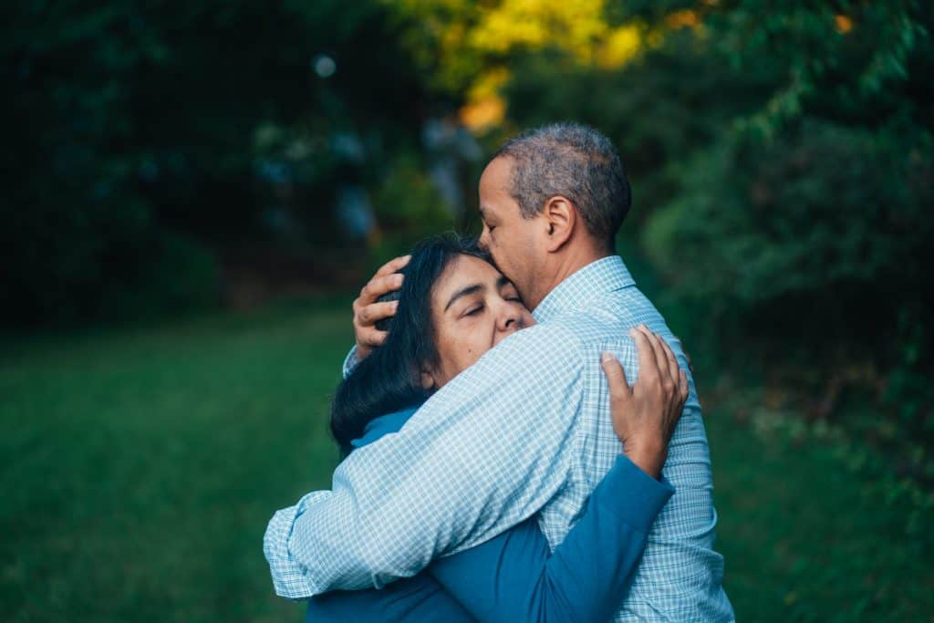 Photo by Gus Moretta man hugging woman near trees