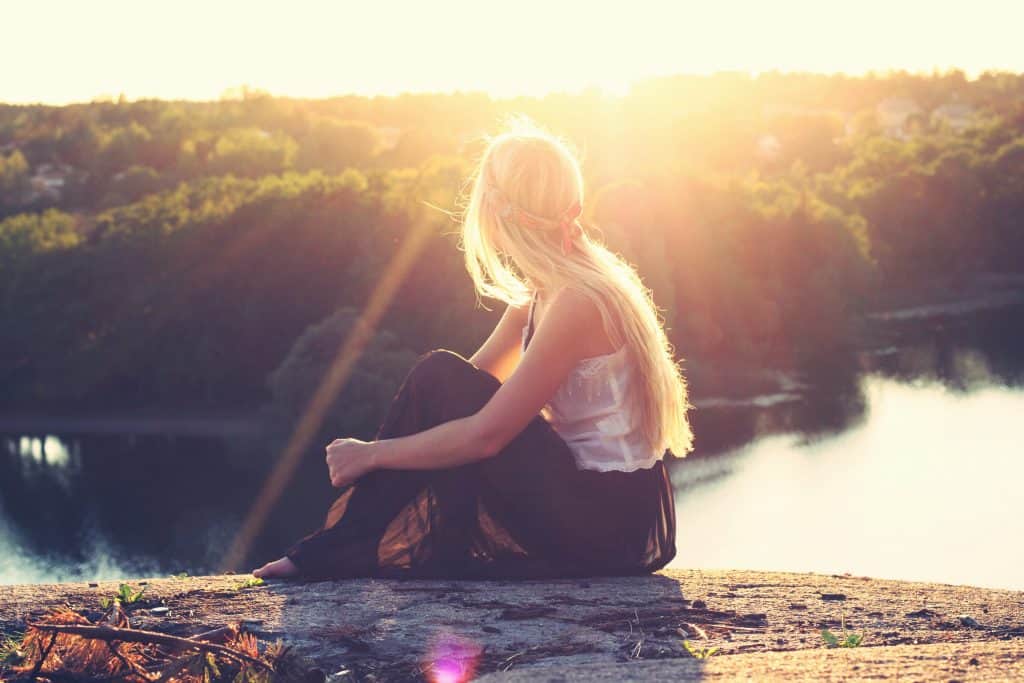 Photo by Julia Caesar woman sitting on brown surface watching at body of water