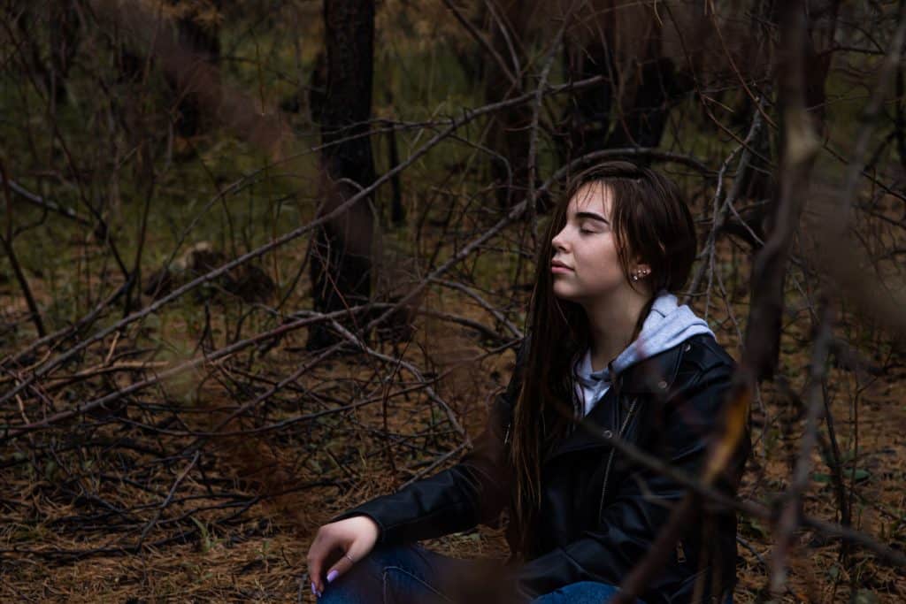 Photo by Andriyko Podilnyk woman in black jacket sitting on brown grass during daytime