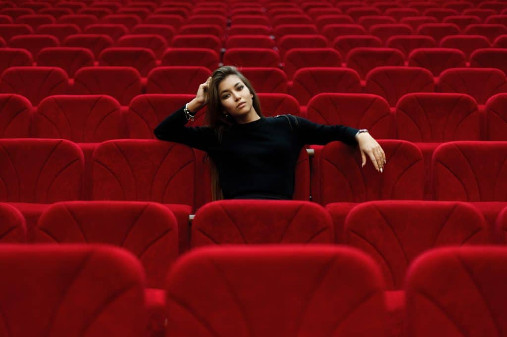 Photo by Vladimir Fedotov woman in black long sleeve shirt sitting on red chair
