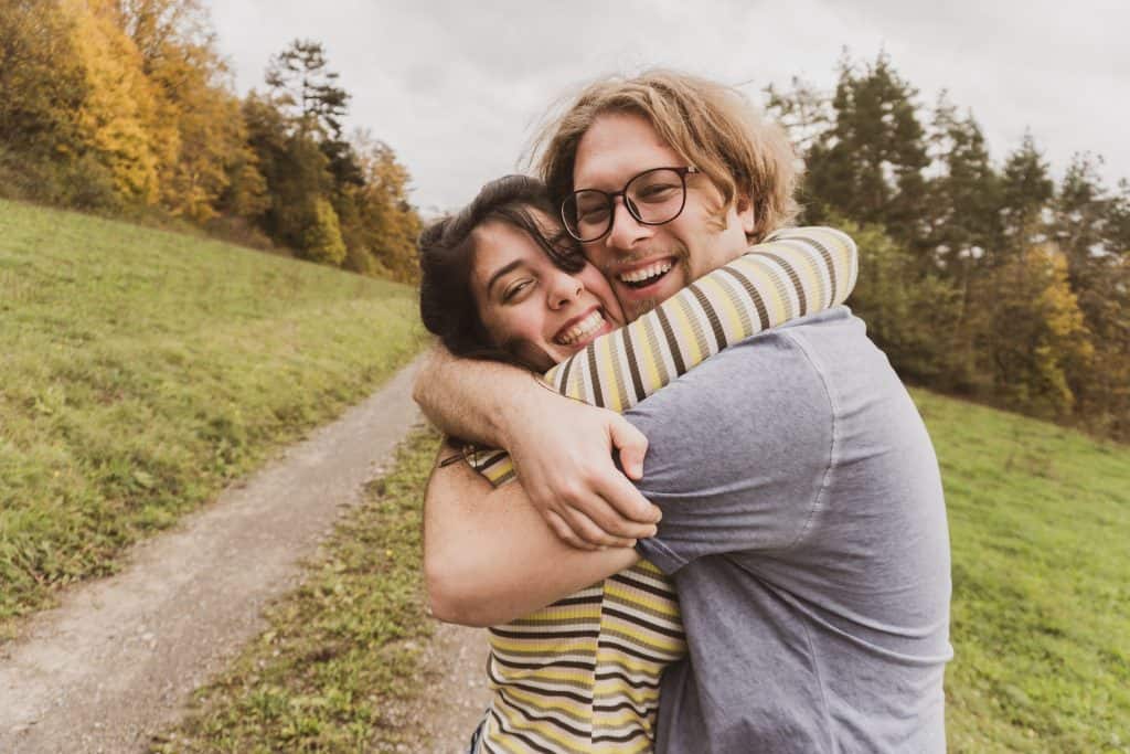 Photo by Tani Eisenstein man and woman hugging near trees